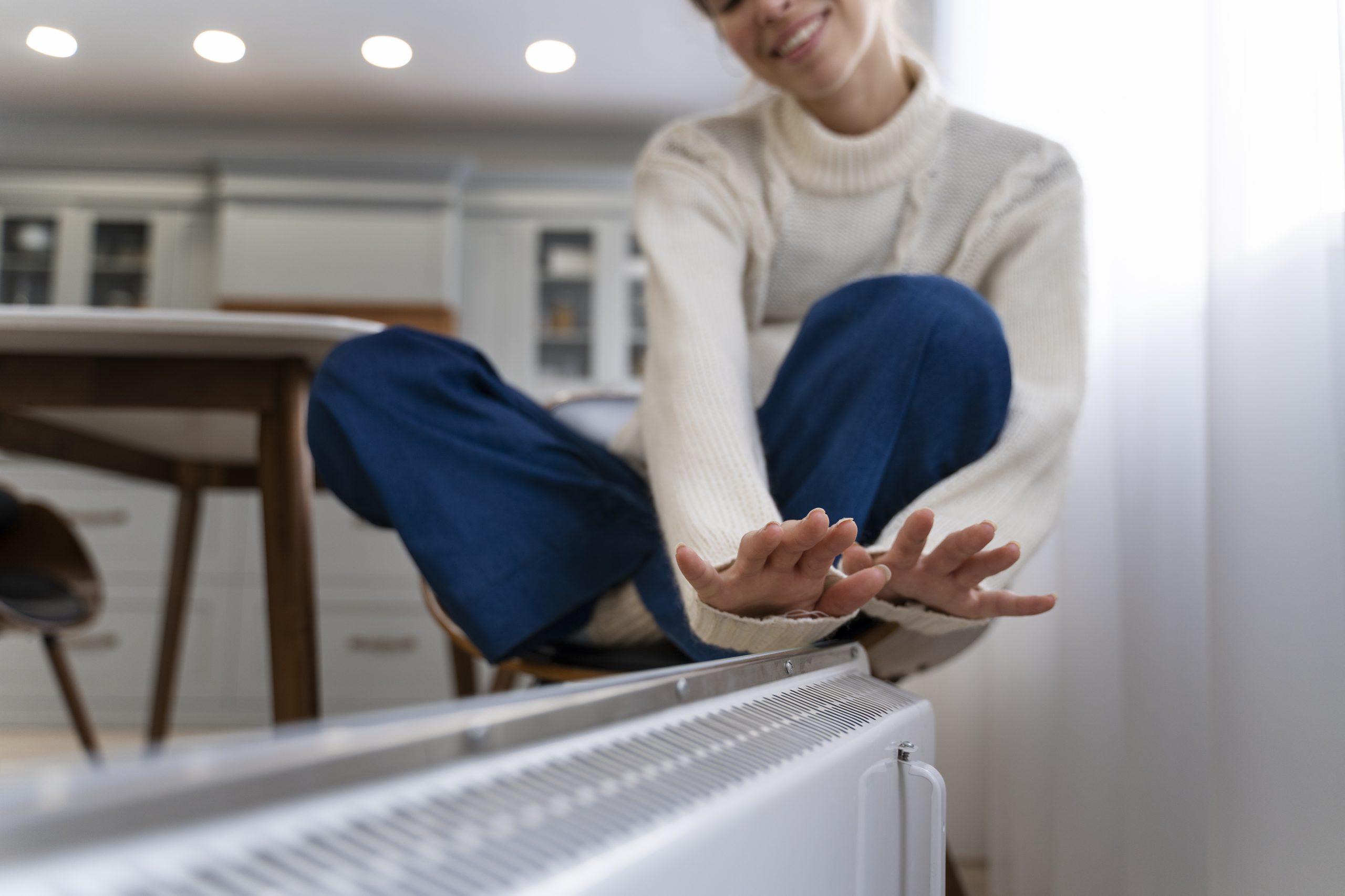 smiley-woman-sitting-near-heater-home